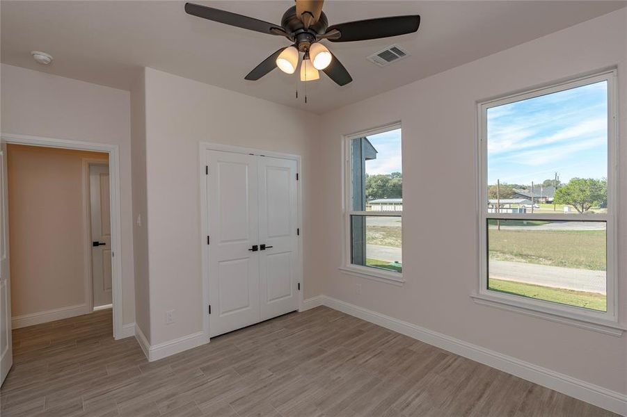 Unfurnished bedroom with a closet, light wood-type flooring, and ceiling fan