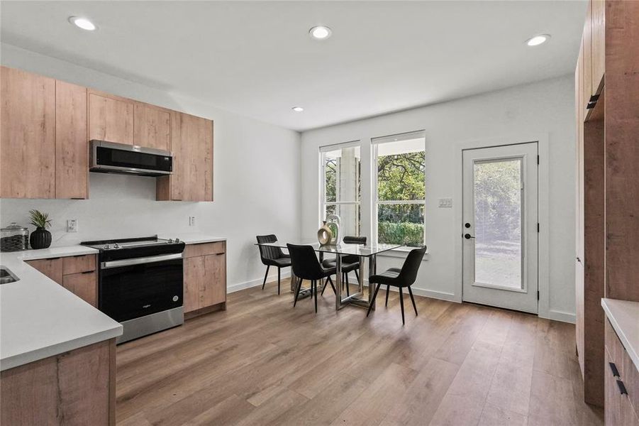 Kitchen featuring stainless steel appliances and light hardwood / wood-style flooring