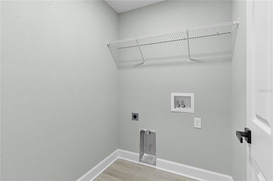 Inside laundry room with overhead shelf