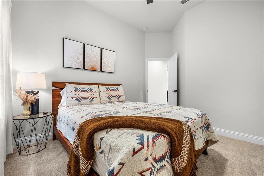 Bedroom with lofted ceiling and carpet floors