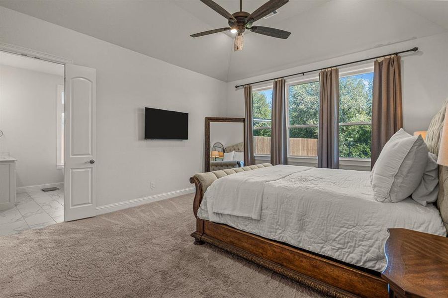 Carpeted bedroom featuring lofted ceiling and ceiling fan