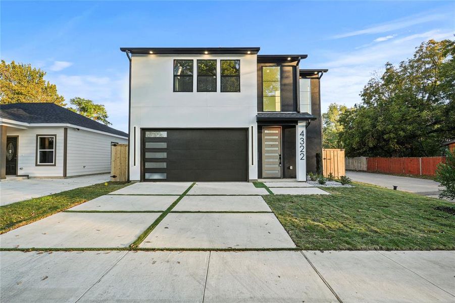 Contemporary home with a front lawn and a garage