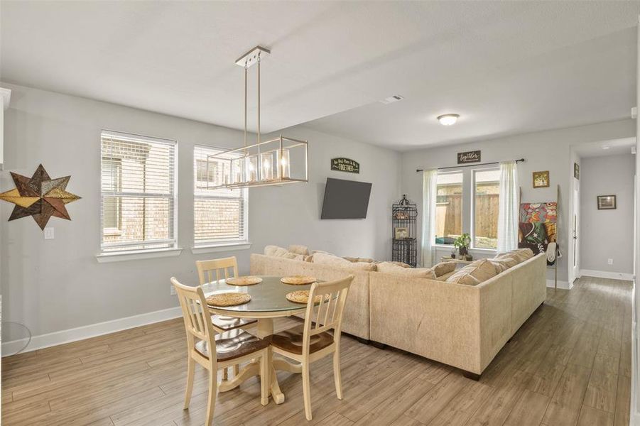 Dining area with a wealth of natural light, light wood-type flooring, and a chandelier