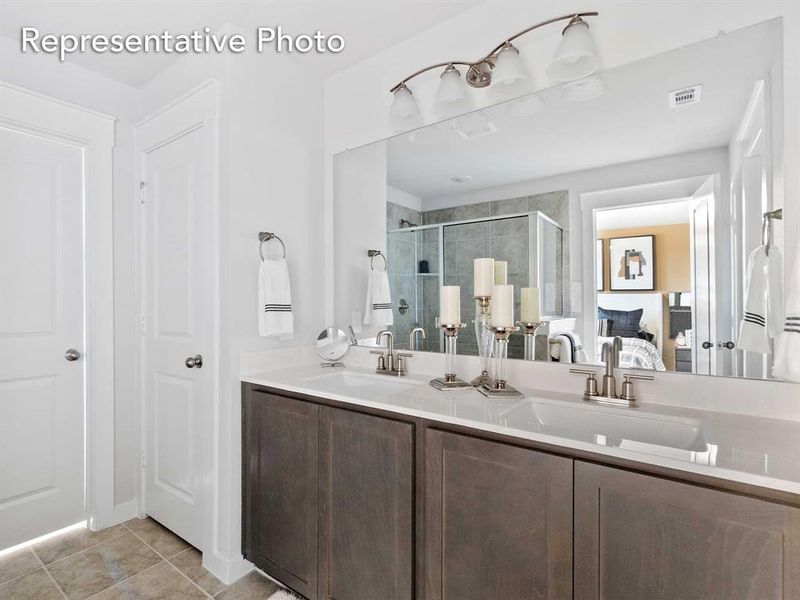 Bathroom featuring tile patterned flooring, walk in shower, and vanity