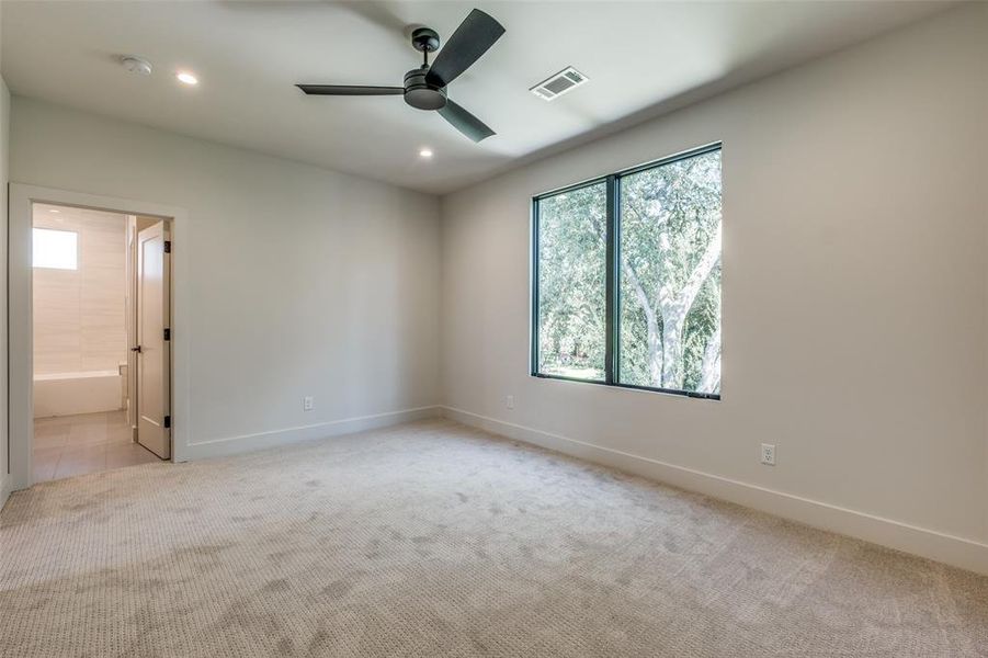 Spare room featuring light carpet and ceiling fan