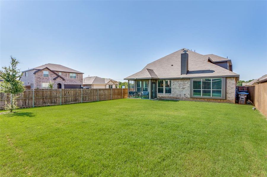 Back of property featuring a sunroom and a yard