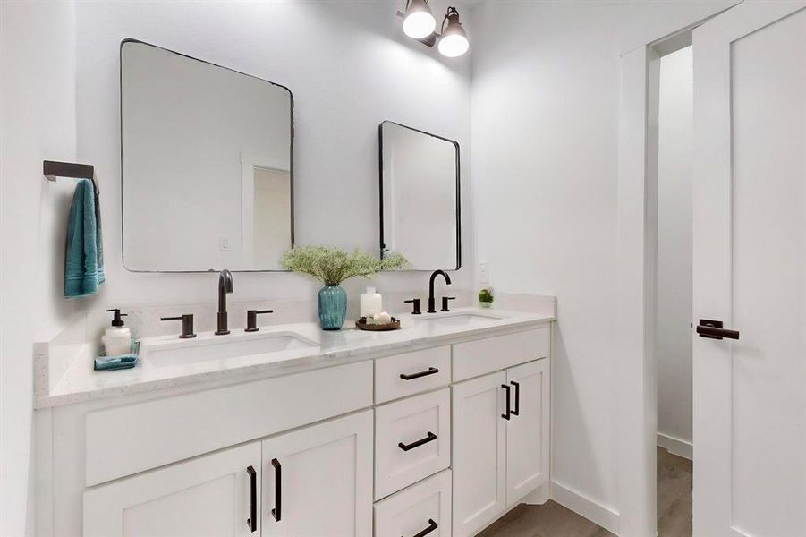 Staged Main Bathroom with hardwood / wood-style flooring and double sink vanity