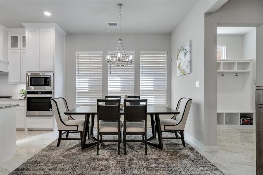 Tiled dining area featuring a notable chandelier