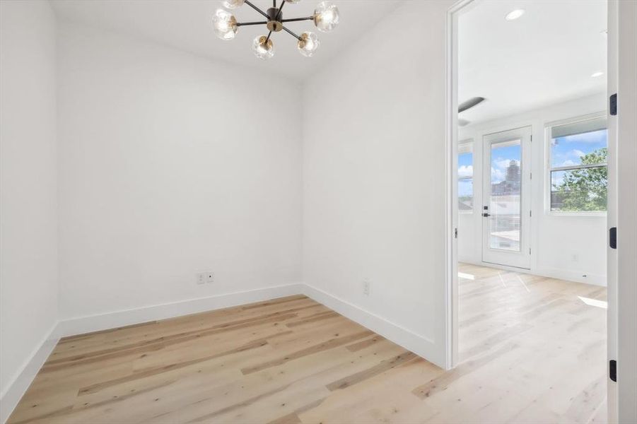 Unfurnished room featuring light hardwood / wood-style floors and a chandelier