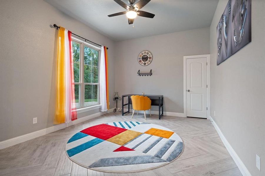 Bedroom with ceiling fan and light parquet floors