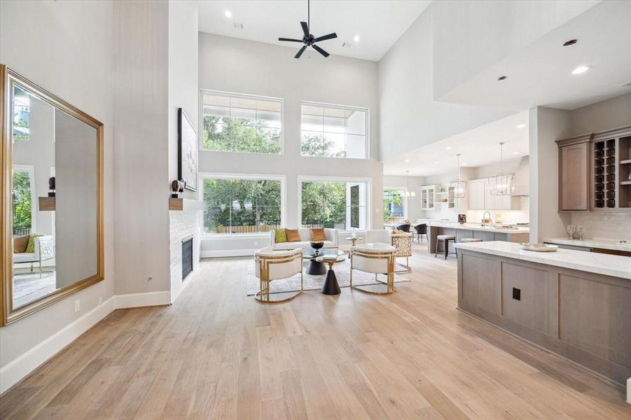 This is a spacious and modern open-concept living space featuring high ceilings, large windows for plenty of natural light, a beautiful wet bar that blend perfectly with this sleek gourmet island kitchen.