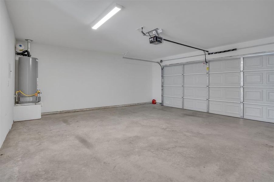 Garage featuring a garage door opener and gas water heater