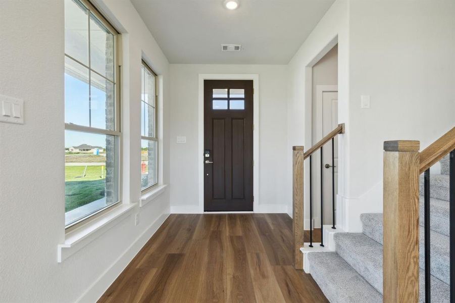 Foyer entrance with dark hardwood / wood-style floors