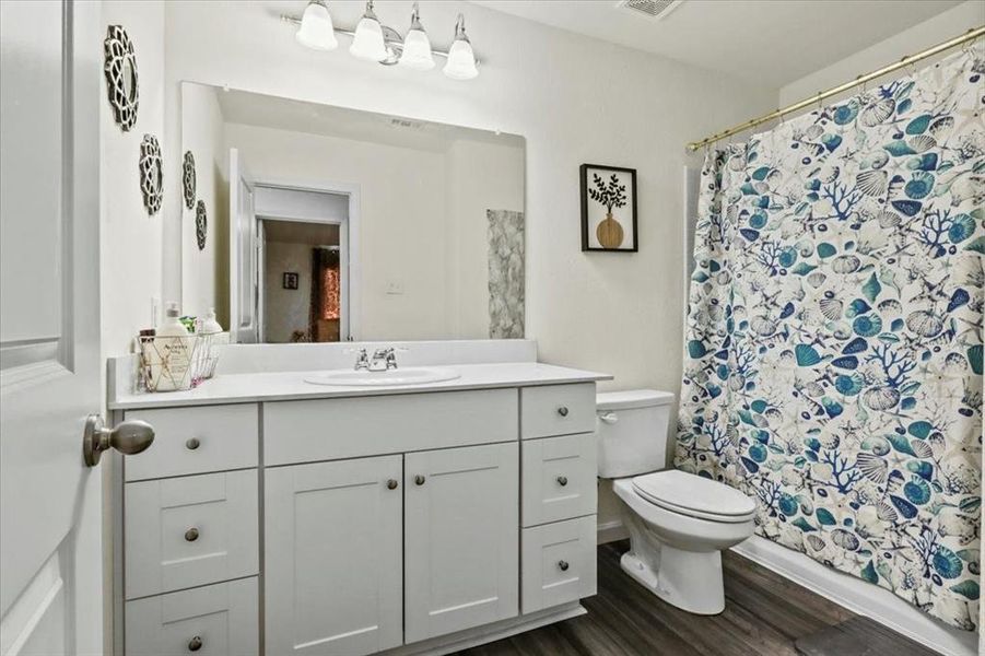 Bathroom featuring hardwood / wood-style floors, vanity, and toilet