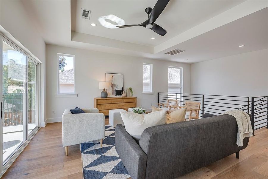 Living room featuring light hardwood / wood-style flooring, a wealth of natural light, and ceiling fan