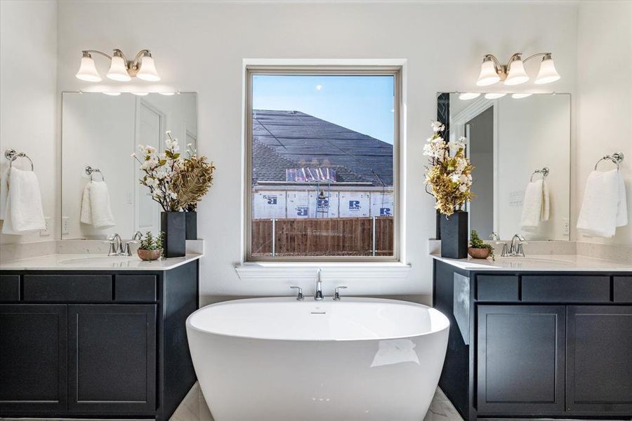 Master bathroom with dual sinks and stand alone tub