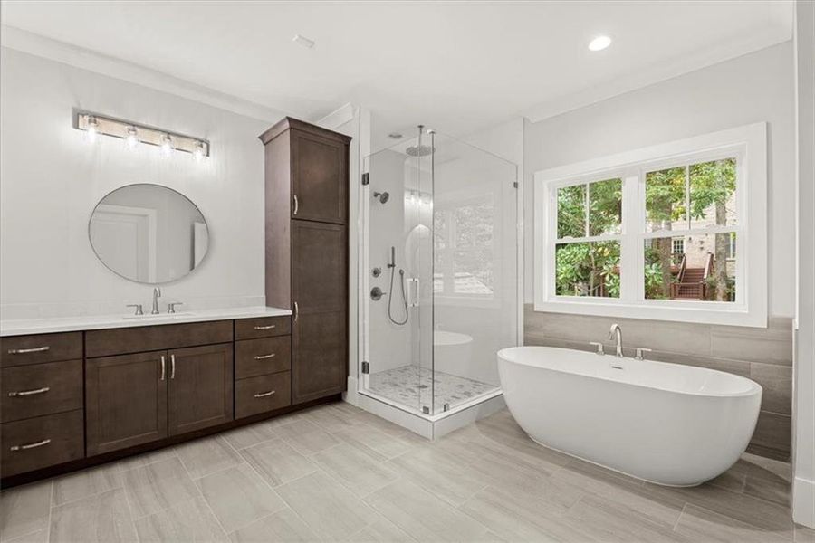 Bathroom featuring tile flooring, vanity, and separate shower and tub