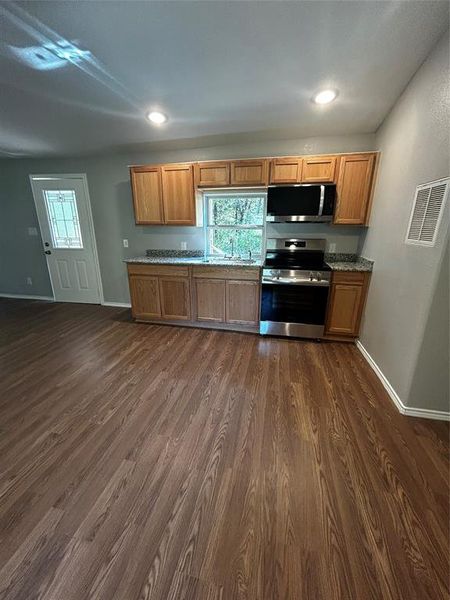 Kitchen with range, sink, and dark wood-type flooring