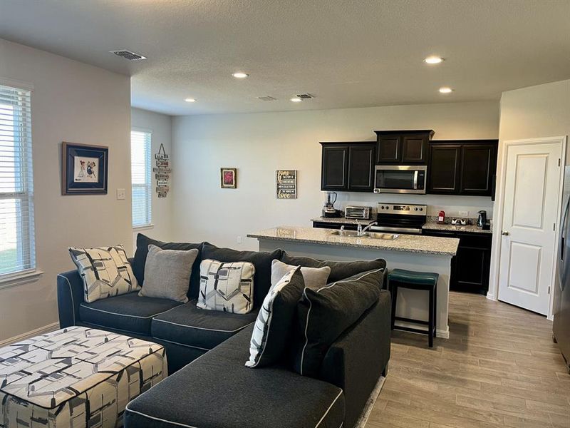 Living room featuring sink, light hardwood / wood-style floors, and a textured ceiling