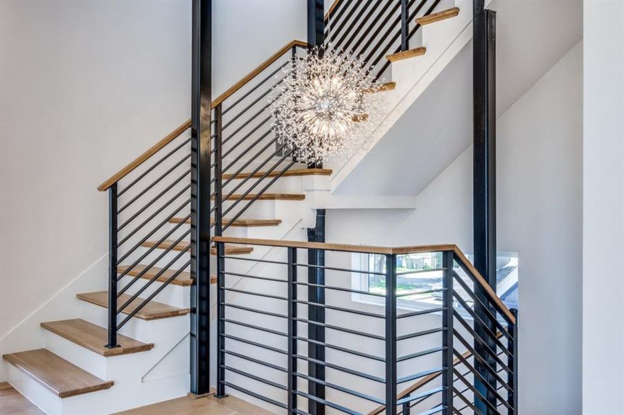 Stairway featuring an inviting chandelier and wood-type flooring