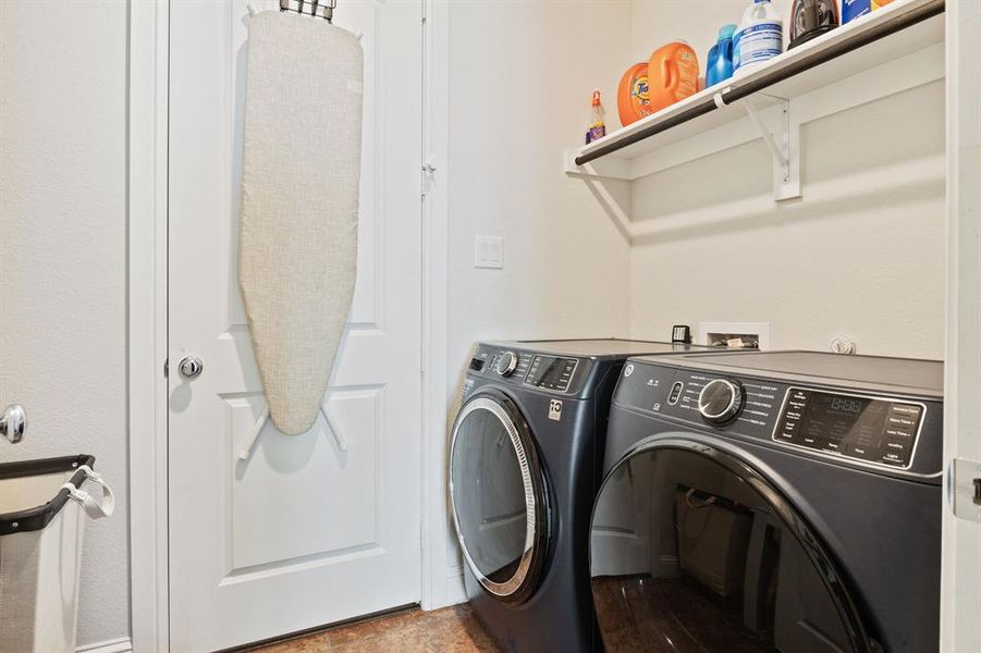 Laundry area with washer hookup, dark tile flooring, and washer and clothes dryer