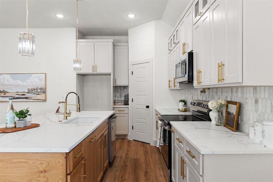 Kitchen with appliances with stainless steel finishes, sink, and white cabinets