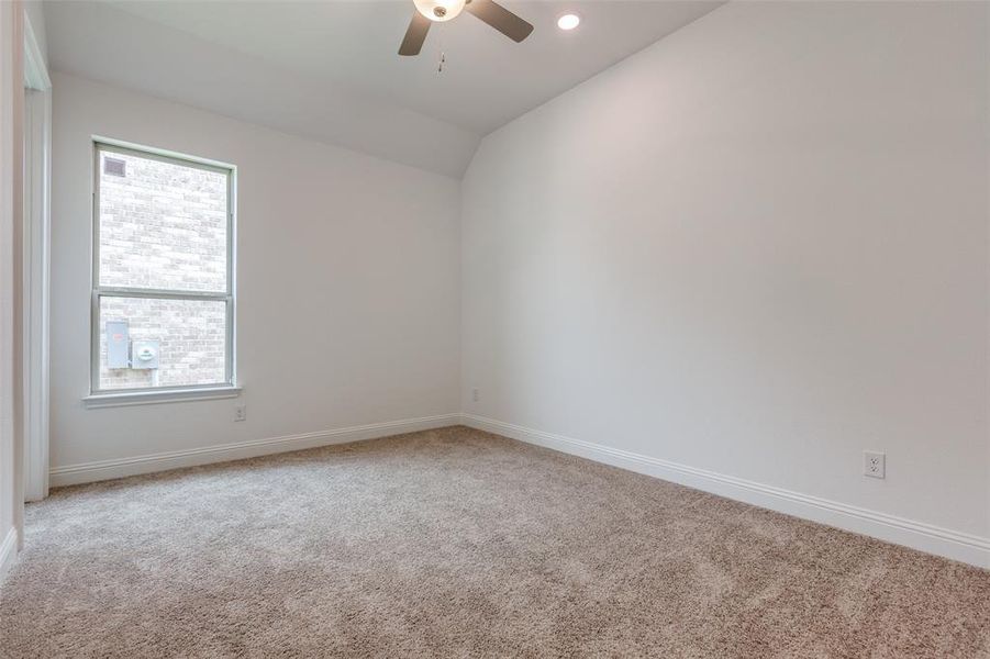 Bedroom with carpet, ceiling fan, and vaulted ceiling