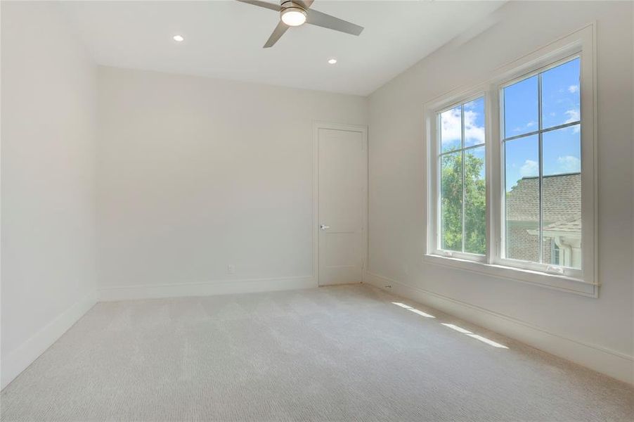 1 of 3 spacious upstairs Secondary Bedrooms with luxury carpet, modern ceiling fans, LED recessed lights, large windows and walk-in closets with built-in shelving and cabinets.