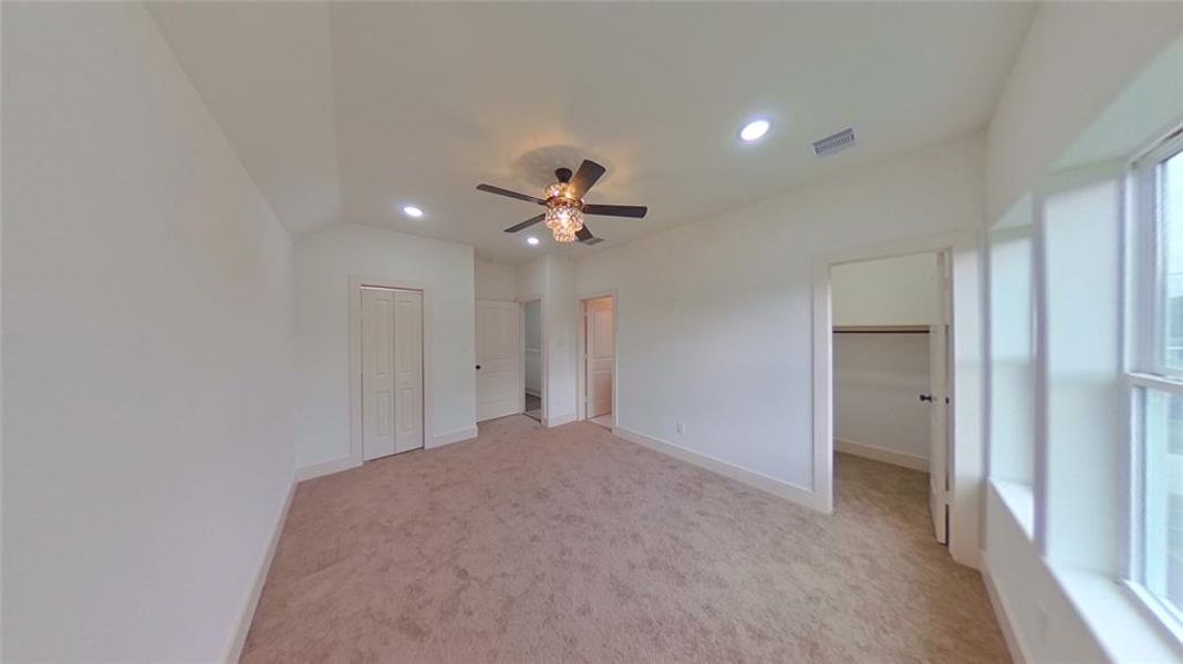 4209 Tampico St. Welcome to your Primary bedroom displaying triple-tiered crystal lighting with a fan, a vaulted ceiling, cozy carpeting and 2 walk-in closets.