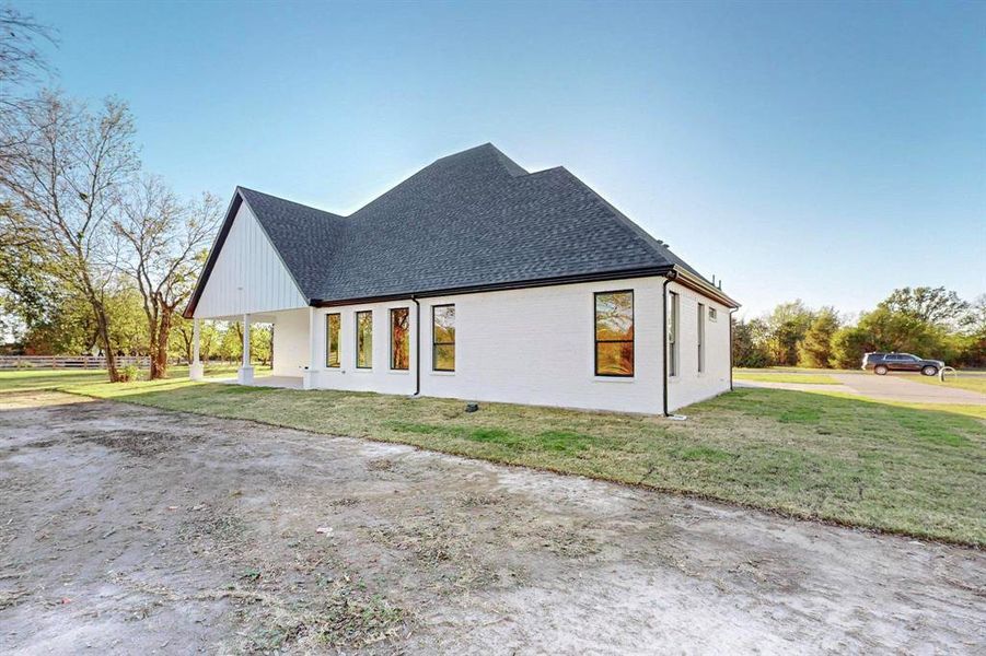 View of side of home featuring a yard