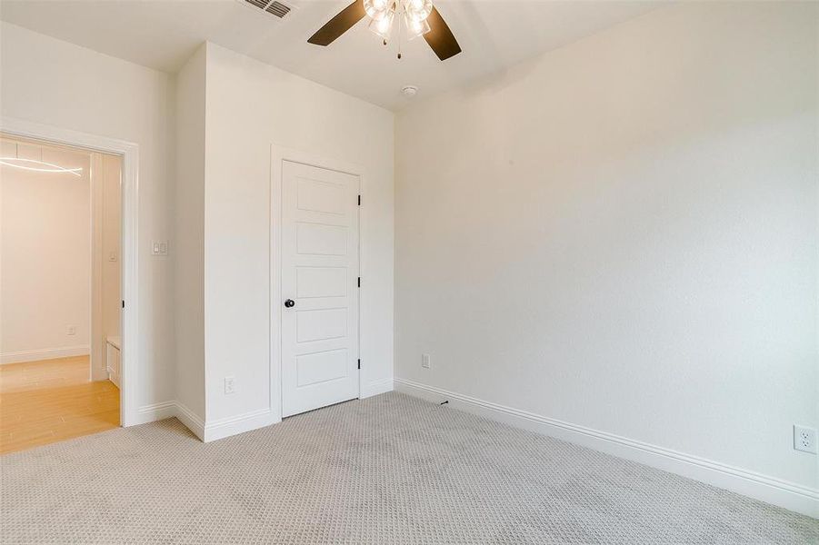 Unfurnished bedroom featuring light carpet and ceiling fan