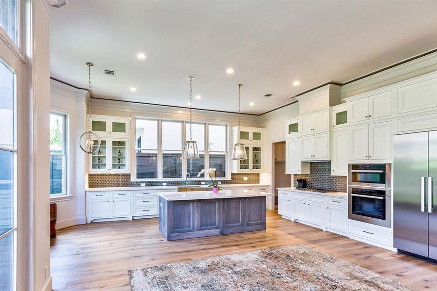 Stunning chef's kitchen with upgraded stacked cabinets, luxe white marble features and SS Fisher Paykel appliances