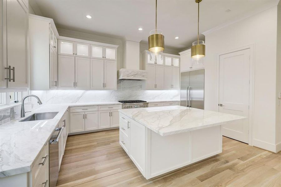 This well designed cooks kitchen is made for convenience while keeping with a graceful and elegant aesthetic. Huge prep island/breakfast bar, contemporary pendant lighting above the large marble island with breakfast bar and storage!