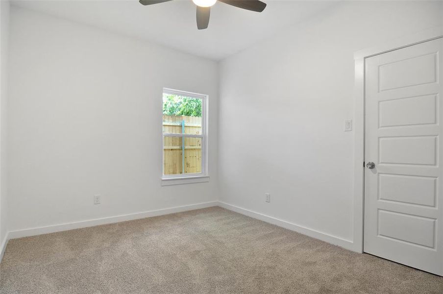 Carpeted spare room featuring ceiling fan