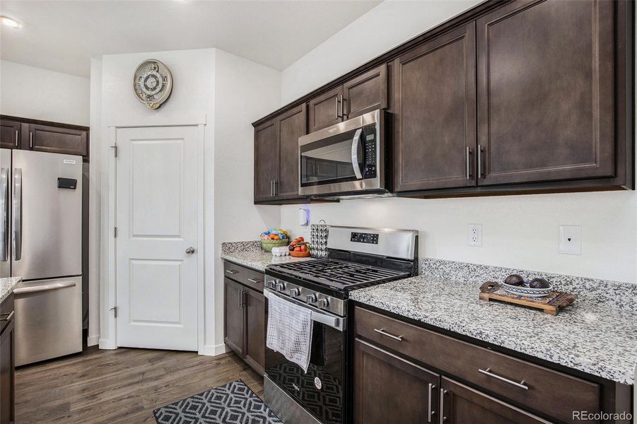 Kitchen featuring a gas stove, large pantry and granite countertops.