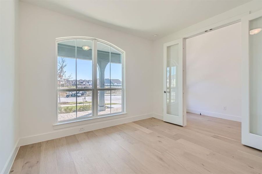 Empty room with french doors and light hardwood / wood-style floors