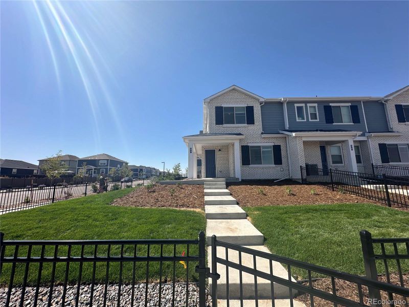 View from sidewalk of fenced in yard