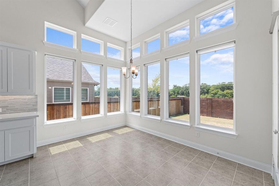 Unfurnished sunroom featuring a wealth of natural light and a chandelier