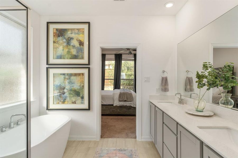 Bathroom featuring vanity, hardwood / wood-style flooring, and a tub to relax in