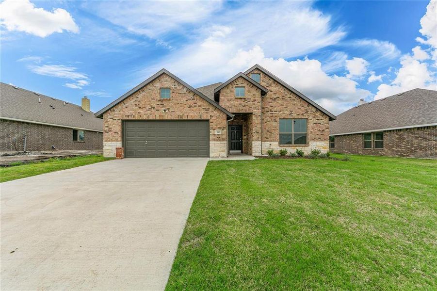 View of front of home featuring a garage and a front yard