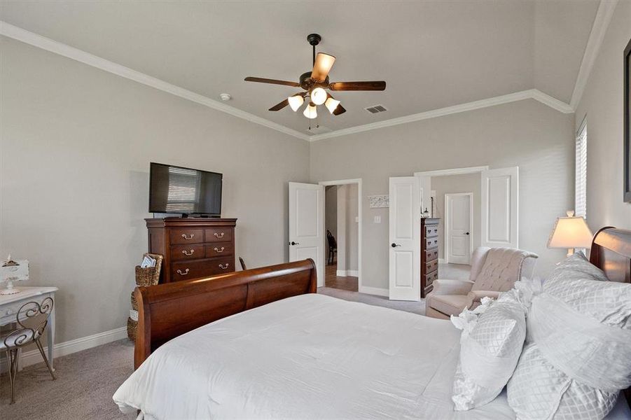 Bedroom featuring ceiling fan, ornamental molding, carpet floors, and lofted ceiling