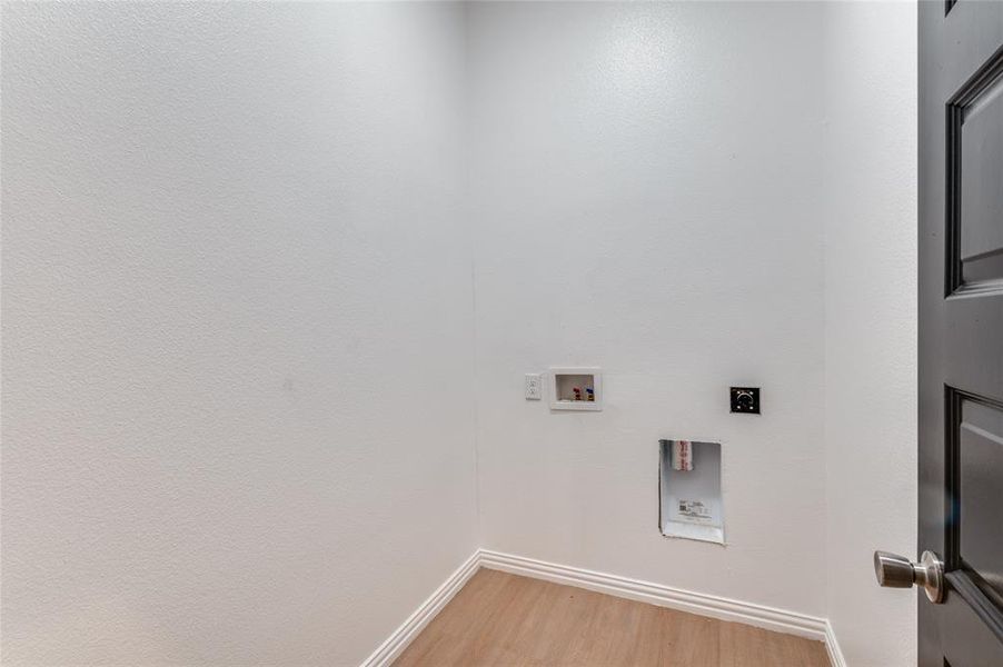 Washroom featuring light wood-type flooring, hookup for a washing machine, and hookup for an electric dryer