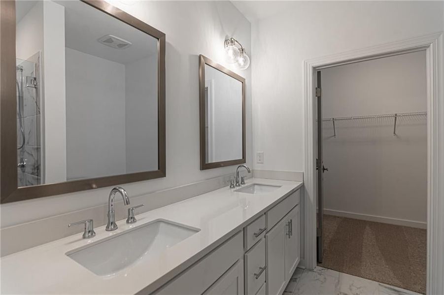 Step into your large primary bathroom with dual vanity, tiled walk in shower with frameless shower door and entry to your walk in closet. *Not actual home-Representative purposes only*