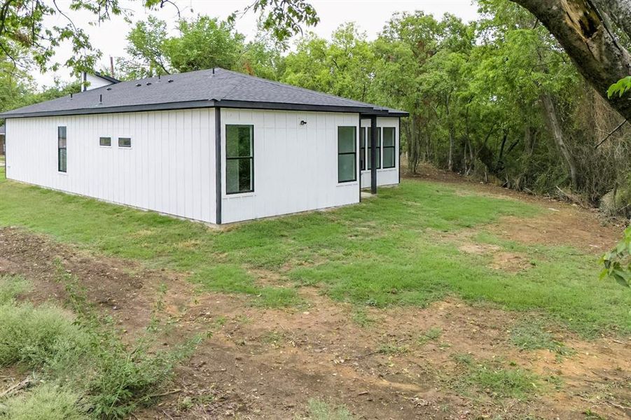 View of side of property featuring a yard