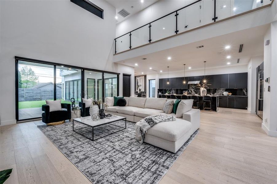 Living room featuring light hardwood / wood-style floors and a towering ceiling