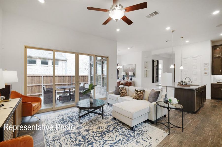 Living room with ceiling fan, sink, and dark wood-type flooring