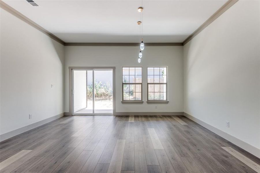 Empty room with hardwood / wood-style flooring and ornamental molding