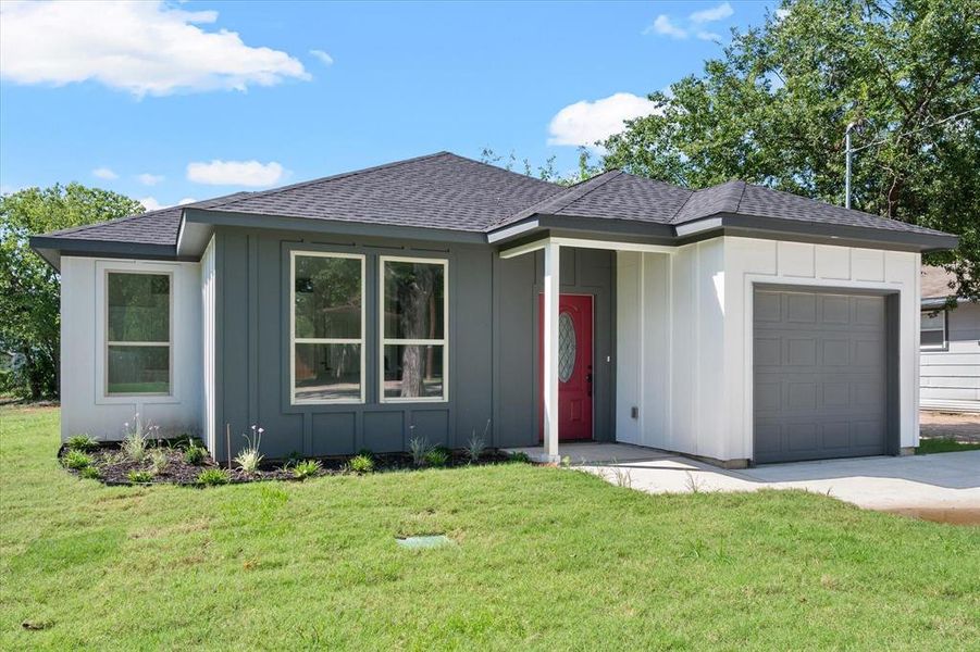 View of front of home with a garage and a front yard