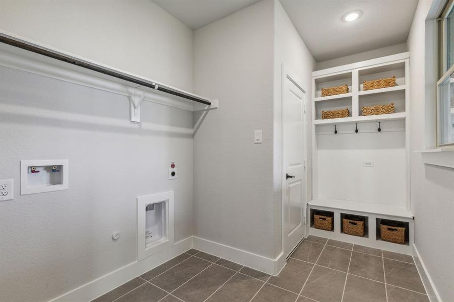 Clothes washing area featuring gas dryer hookup, hookup for a washing machine, electric dryer hookup, and dark tile patterned flooring