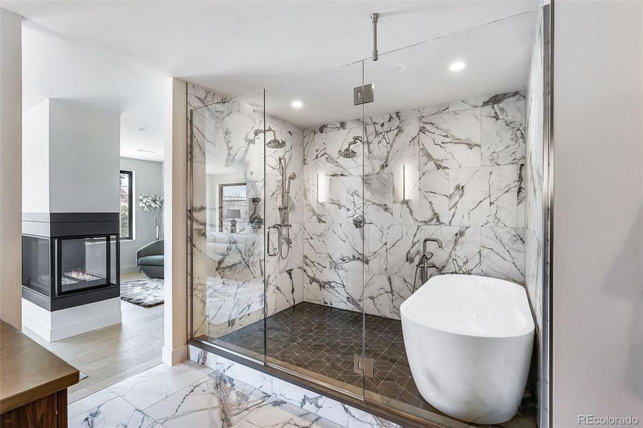 Primary bath wet room houses the oversized tub and double shower heads.